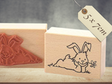 Stempel Osterhase mit Blume im Gras zu Ostern